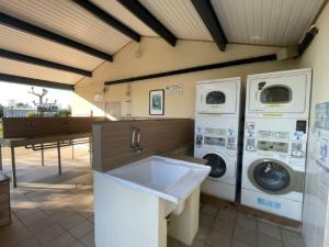 eine Waschküche mit zwei Waschmaschinen und einem Waschbecken in der Unterkunft Chalet à Saint-Pierre-d'Oléron avec Terrasse - API-1-52-1111 in Dolus d'Oléron