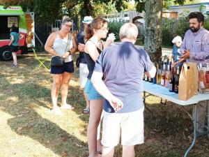 un gruppo di persone che si trovano intorno a un tavolo con bottiglie di vino di Mobil home confortable avec terrasse - API-1-52-1115 a Luynes