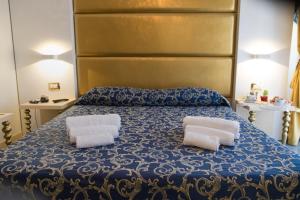 a bedroom with a bed with two towels on it at Hotel Ambassador in Rimini