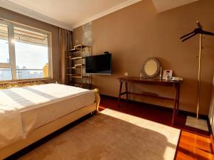 a bedroom with a bed and a television and a table at Panoramic views of the Bund and the Yangtze River, adjacent to the Oriental Pearl Tower, a top-tier luxury residence in Shanghai in Shanghai