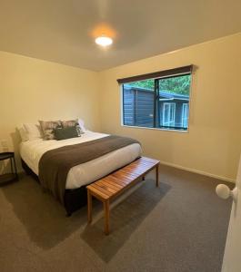 een slaapkamer met een groot bed en een raam bij Gordonton Greenmeadows Cottage in Taupiri