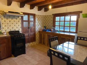 a kitchen with a stove and a table in it at Cabañas Las Camelias in Cuetzalán del Progreso