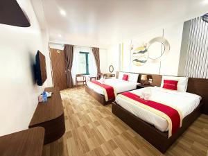 a hotel room with two beds and a mirror at Avenue Hotel VangVieng in Vang Vieng +29 photos