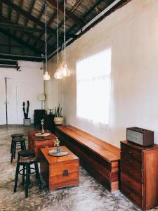 uma sala com um grande banco de madeira e uma janela em Khemjit cafe' and bed em Ban Kao