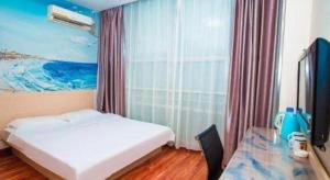 ein Schlafzimmer mit einem Bett und einem Schreibtisch mit einem Fernseher in der Unterkunft Super 8 Hotel Jinan Railway Station Square in Jinan