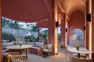 un patio con mesas y sillas y un sofá en Wanda Yi, Suite Xishuangbanna, en Jinghong