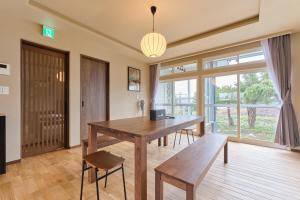 a dining room with a wooden table and chairs at Casa Katatsumuri in Nakafurano