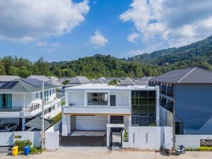 a large white house with a lot of houses at Bangtao New Luxury 7 Bedrooms Modern Space Aesthetic Design Private Pool Villa Private Movie Theater in Ban Nong Chaeng