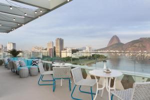a balcony with tables and chairs and a view of the city at Yoo2 Rio de Janeiro by Intercity in Rio de Janeiro