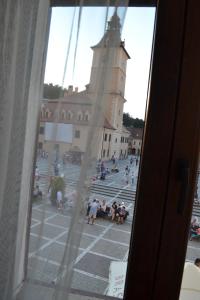 布拉索夫Casa Krone - Piața Sfatului的从带钟楼建筑的窗户欣赏美景