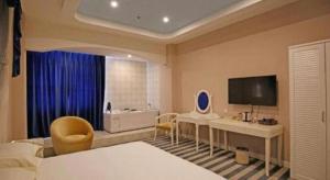 ein Hotelzimmer mit einem Bett, einem Schreibtisch und einem Fernseher in der Unterkunft TO915101 STILL LOVE THEME HOTEL in Chengdu + 71 Fotos