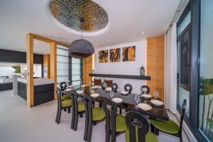 a dining room with a long table and chairs at Bangtao New Luxury 7 Bedrooms Modern Space Aesthetic Design Private Pool Villa Private Movie Theater in Ban Nong Chaeng
