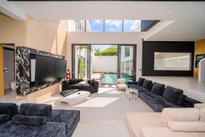 a living room with a large couch and a tv at Bangtao New Luxury 7 Bedrooms Modern Space Aesthetic Design Private Pool Villa Private Movie Theater in Ban Nong Chaeng