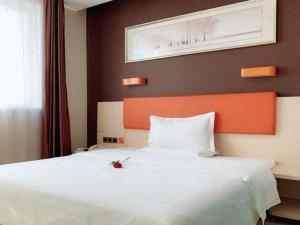 a bedroom with a large white bed with an orange headboard at 7 Days Premium Beijing Dabaotai Metro Station Luhua Road in Beijing +244 photos