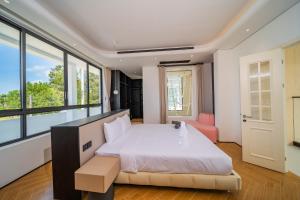 a bedroom with a large bed and large windows at Bangtao New Luxury 7 Bedrooms Modern Space Aesthetic Design Private Pool Villa Private Movie Theater in Ban Nong Chaeng +66 photos
