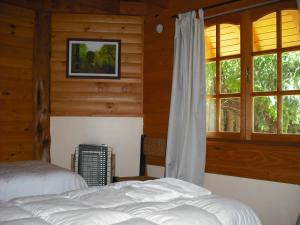 Un dormitorio con dos camas y una ventana. en Las Bahías, en Villa La Angostura