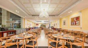 a restaurant with wooden tables and chairs and a chandelier at Guangzhou Xiangjiang Health Valley in Zengcheng
