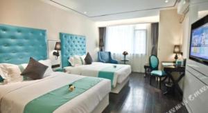 a hotel room with two beds and a flat screen tv at Xana Lite Leshan Haochi Street Branch in Leshan