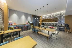 ein Restaurant mit Holztischen und Stühlen und einer Theke in der Unterkunft SOFIS POP HOTEL in Fuzhou