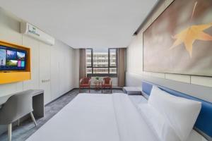 Una cama o camas en una habitación de 7 Days Inn Tai'an Dongpingxi Hualian 109 fotos más