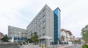 ein großes Gebäude an einer Stadtstraße mit Gebäuden in der Unterkunft Xana Hotelle·JiNan Daminghu East Gate Shandong University in Jinan