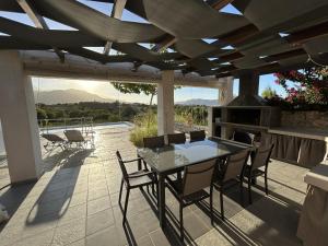 eine Terrasse mit einem Tisch, Stühlen und einem Kamin in der Unterkunft Villa Maïa in Dhrámia