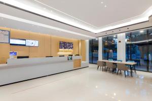 a lobby with a cafeteria with tables and chairs at City Comfort Inn Wuhan Ikea in Wuhan