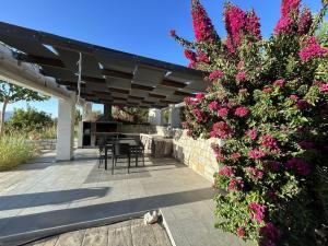 eine Terrasse mit rosa Blumen und einem Zaun in der Unterkunft Villa Maïa in Dhrámia