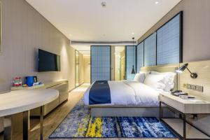 a hotel room with a bed and a desk and a desk at Echarm Hotel Nanning Baisha Avenue Tingjiang Interchange BBK in Nanning +178 photos