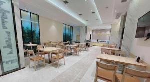 a dining room with tables and chairs and windows at City Comfort Inn Wuhan University Guangbutun Metro Station in Wuhan +217 photos