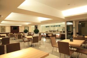 a restaurant with tables and chairs and a counter at City Comfort Inn Yulin Jincheng Center Municipal Government in Yulin