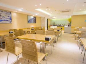 a dining room with wooden tables and chairs at City Comfort Inn Fangcheng Qunxing Avenue in Fangcheng