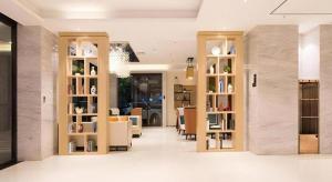un soggiorno con tavoli, sedie e librerie di City Comfort Inn Nanning Shuangyong Road Guangxi Medical University a Nanning