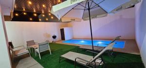 a swimming pool with an umbrella and a table and chairs at Casa Úcu en La Paz, BCS in La Paz