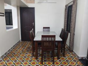 a dining room with a table and chairs and a door at The Sparrow House 2BHK Ground Floor in Kumbakonam +19 photos