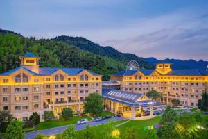 Blick auf ein Hotel mit Bergen im Hintergrund in der Unterkunft Deefly Yinrun Town Hotel in Deqing