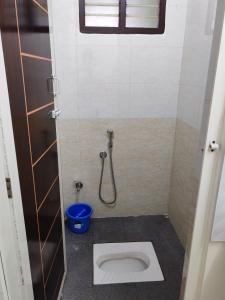 a small bathroom with a toilet and a shower at The Sparrow House 2BHK Ground Floor in Kumbakonam