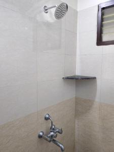 a shower with a shower head in a bathroom at The Sparrow House 2BHK Ground Floor in Kumbakonam