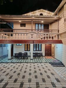 a house with a patio with a table and benches at The Sparrow House 2BHK Ground Floor in Kumbakonam