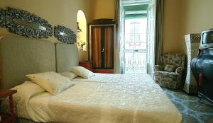 Un dormitorio con una cama grande y una ventana en Alameda Palacete, en Cáceres