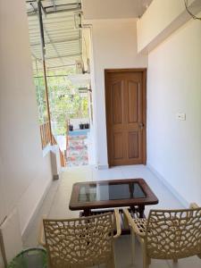 ein Raum mit einem Tisch und zwei Stühlen und einer Tür in der Unterkunft Marari brezza homestay in Alappuzha + 59 Fotos