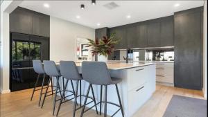 Bella Vista - Coastal Waterviews في Empire Bay: مطبخ مع جزيرة مع كراسي بار