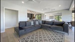 Bella Vista - Coastal Waterviews في Empire Bay: غرفة معيشة مع أريكة وطاولة +9 صور