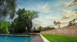 a swimming pool in front of a yard with trees at Ma-Oya Retreat in Andiramada