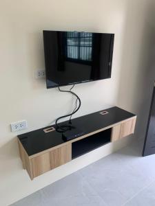 a flat screen tv hanging on a wall at ZAMZAM House in Thalang +8 photos