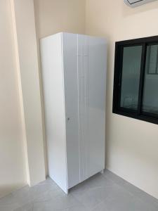a white cabinet in a room with a window at ZAMZAM House in Thalang