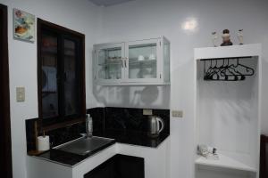 una cucina bianca con lavandino e specchio di Jmt Star's Inn a General Luna