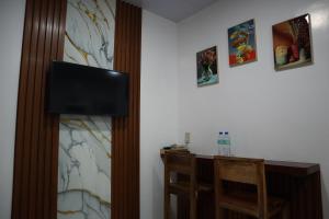 una stanza con una TV a schermo piatto su una parete di Jmt Star's Inn a General Luna