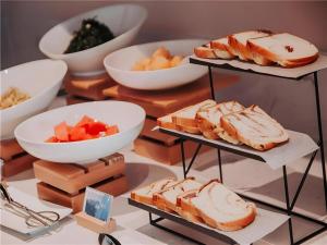 uma mesa com pratos de pão e tigelas de comida em Borrman Hotel Changsha Wuyi Square Yingbin Road Metro Station em Changsha