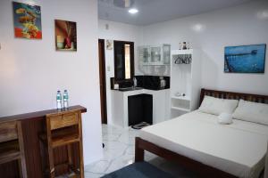 una camera bianca con letto e camino di Jmt Star's Inn a General Luna